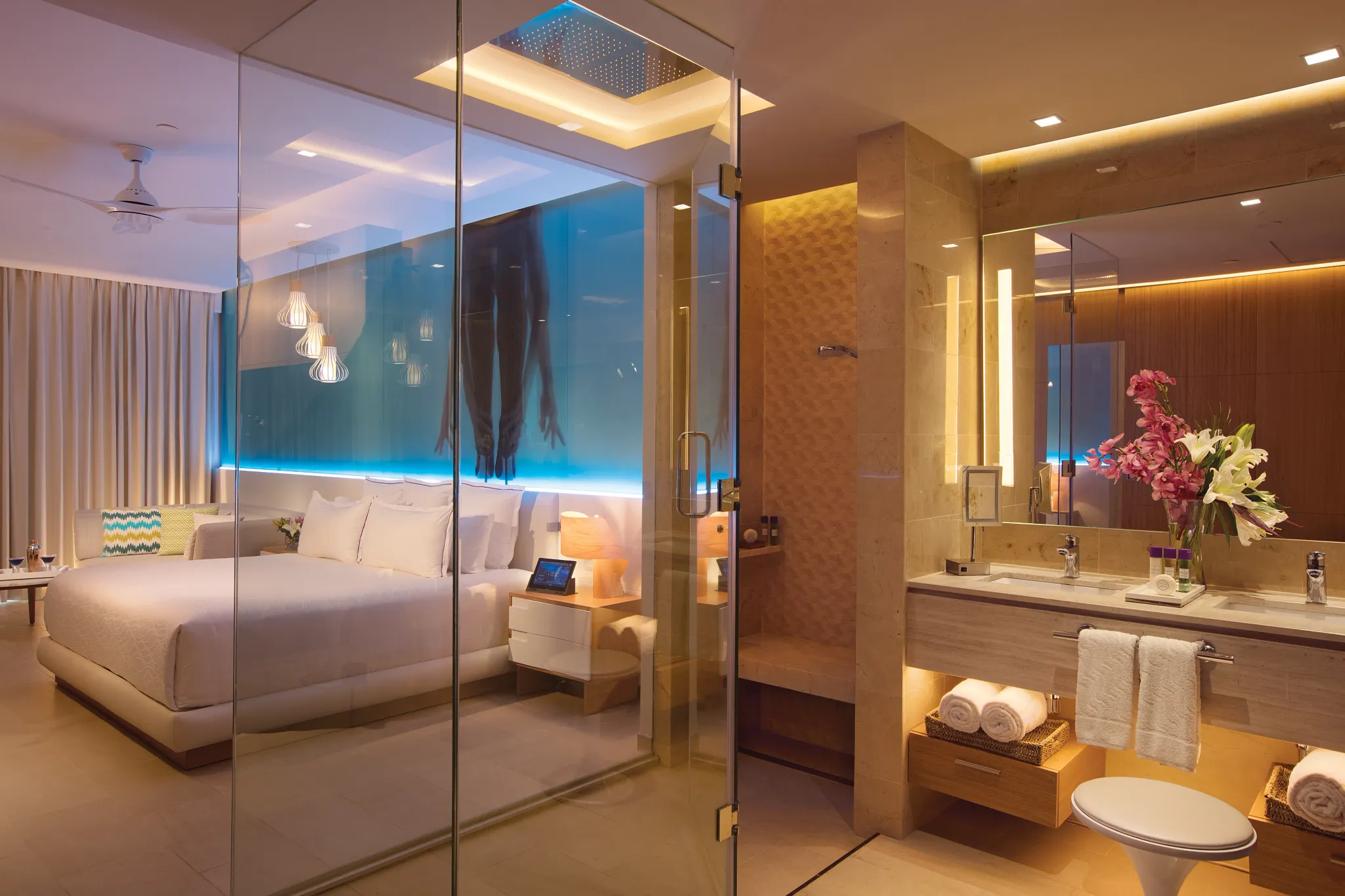 Allure Junior Suite bathroom and bedroom at Breathless Montego Bay featuring modern glass shower, double vanity, mood lighting, and luxurious king bed.
