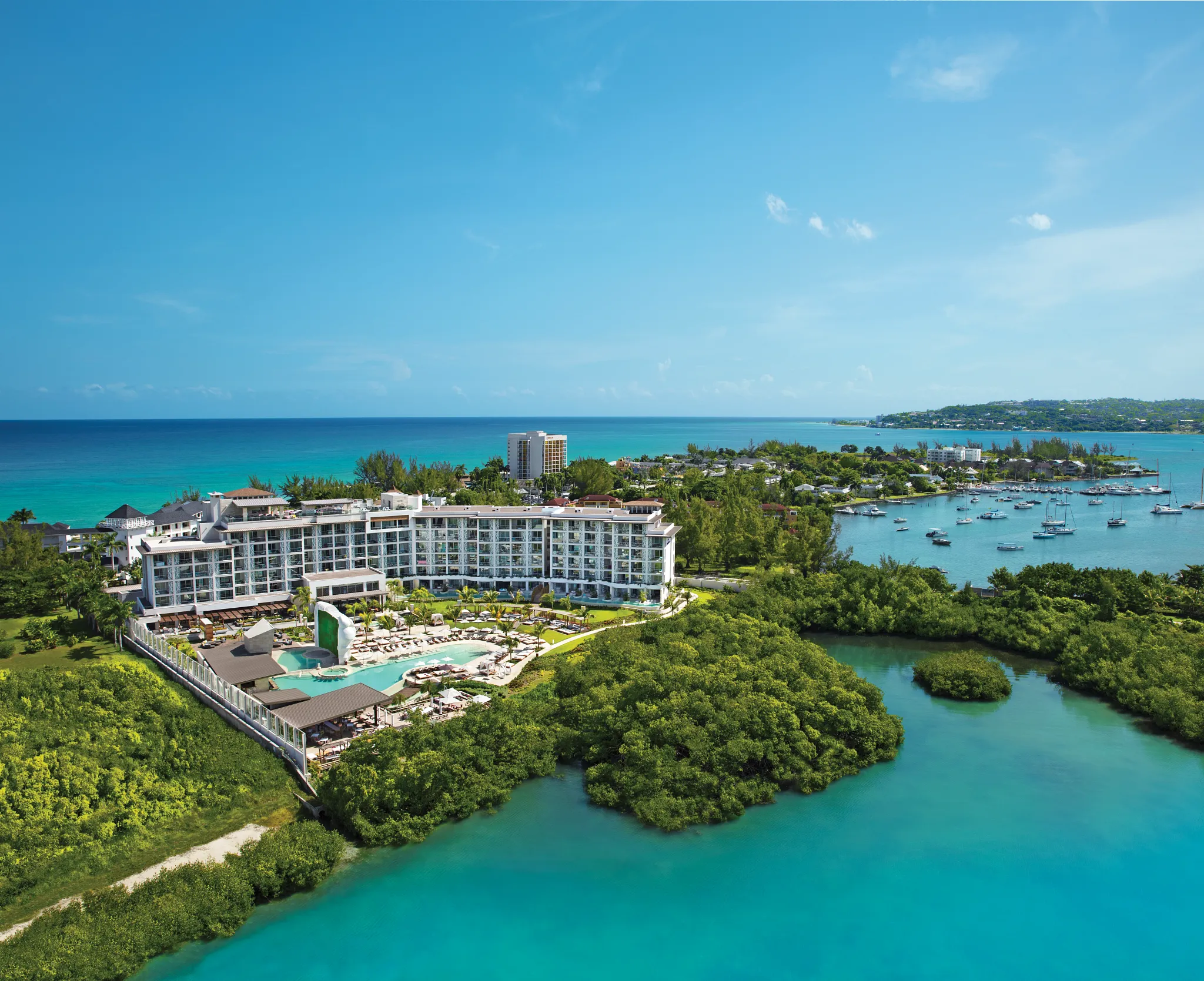 Panoramic aerial view of Breathless Montego Bay Resort overlooking turquoise ocean waters and mangrove coastline.