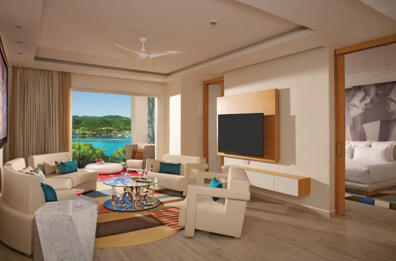 Xhale Club Master Suite Ocean View living room at Breathless Montego Bay with modern seating, large TV, and balcony overlooking the Caribbean Sea.