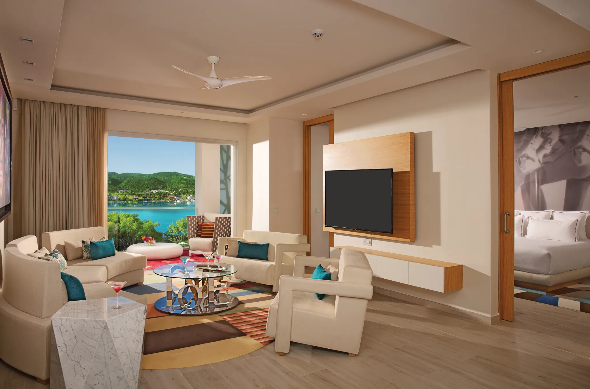 Xhale Club Master Suite Ocean View living room at Breathless Montego Bay with modern seating, large TV, and balcony overlooking the Caribbean Sea.